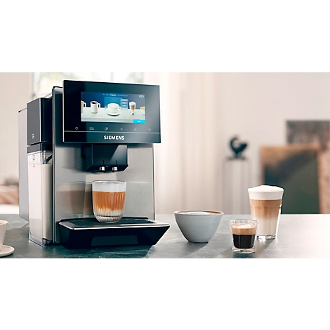Volautomatische koffiemachine met cappuccino in glas, latte macchiato, espresso en een kom.