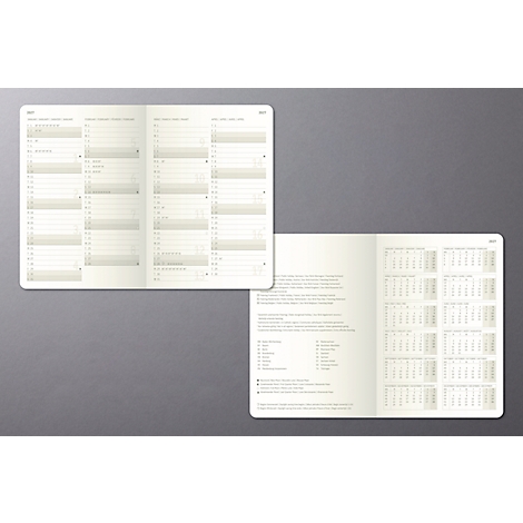 Un carnet ouvert avec des aperçus annuels et hebdomadaires sur un fond gris.