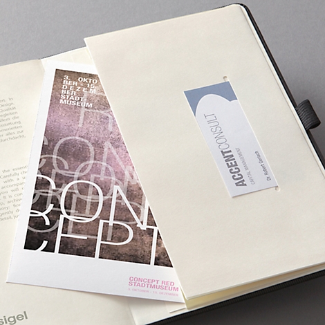 Carnet avec une carte imprimée "Concept Red Stadtmuseum" et un marque-page "Accent Consult".