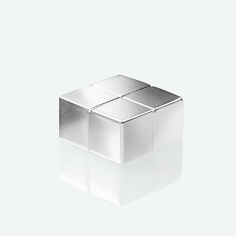 Cube argenté fait de cubes individuels. Il se reflète sur la surface en dessous.