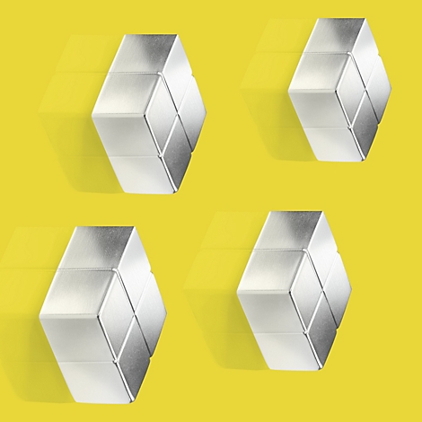 Quatre blocs argentés hexagonaux sur fond jaune avec des ombres.
