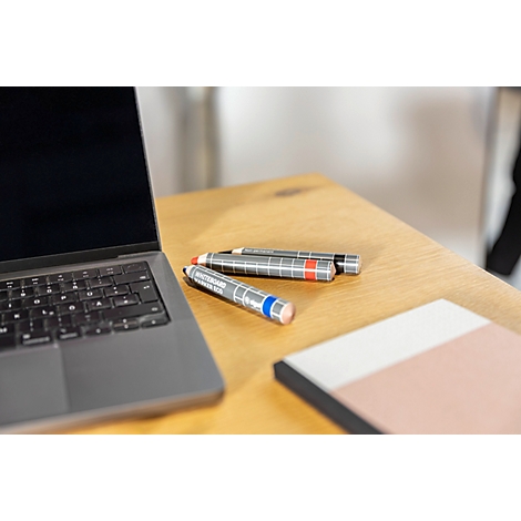 Verschillende gekleurde whiteboard stiften in een houten bakje. Op de stiften staat 'Whiteboard Marker Eco'.