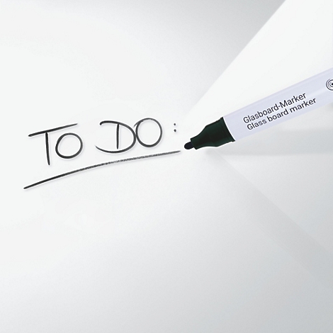 Ein schwarzer Marker schreibt "TO DO:" auf eine weisse Oberfläche. Marker hat "Glasboard-Marker" drauf stehen.