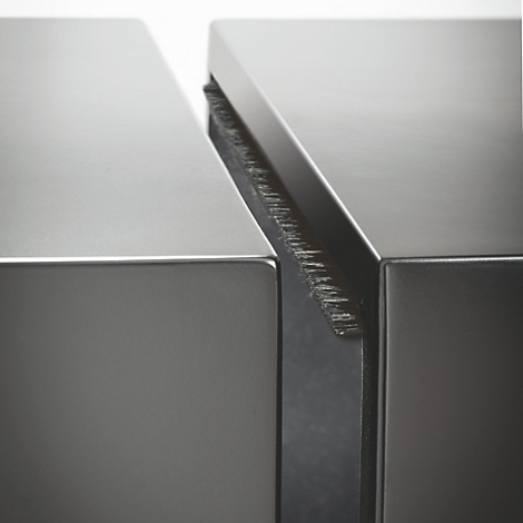 Close-up van twee metalen oppervlakken gescheiden door een smalle opening. De opening heeft een ruw, geborsteld oppervlak.