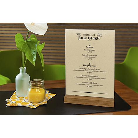 Tafel met menukaart van restaurant Schloss Glienicke, vaas met bloem, glas met drankje.