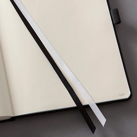Open notebook with black and white bookmarks. The page number 151 is on the corner.