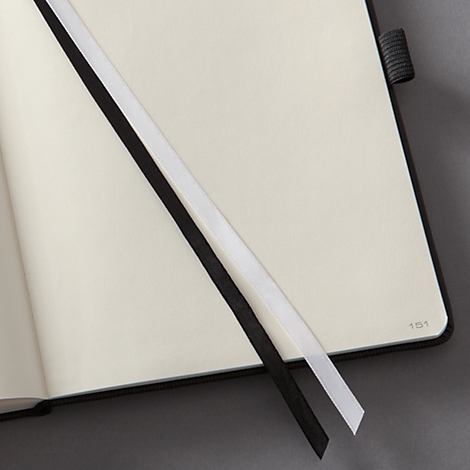 Open notebook with two bookmarks: black and white. The page number 151 is visible.