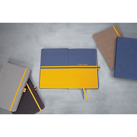 Open blue and yellow notebooks with yellow bookmarks. More books are lying around.