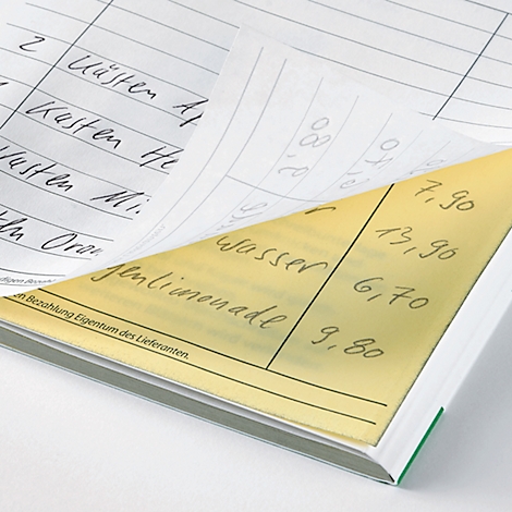 Close-up of an open order book. The pages show handwritten entries of items and prices. The page is partially yellow.