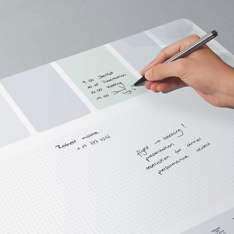 Eine Hand schreibt mit einem Stift auf ein weißes Notizbuch mit Zeitplan-Layout. Notizen beinhalten Termine und Telefonnummern.