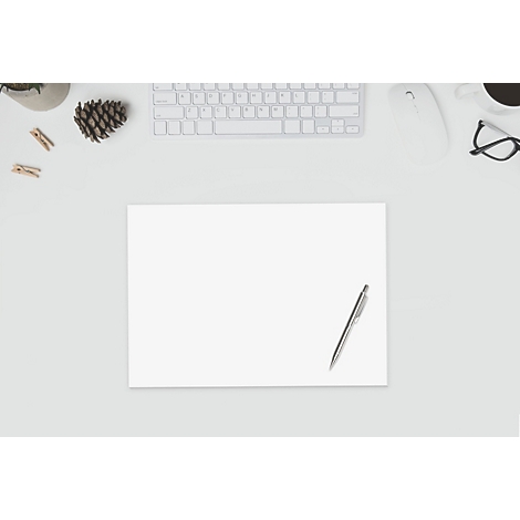 Draufsicht auf einen Schreibtisch mit Papier, Stift, Tastatur, Maus, Brille, Kaffee und Dekoration.