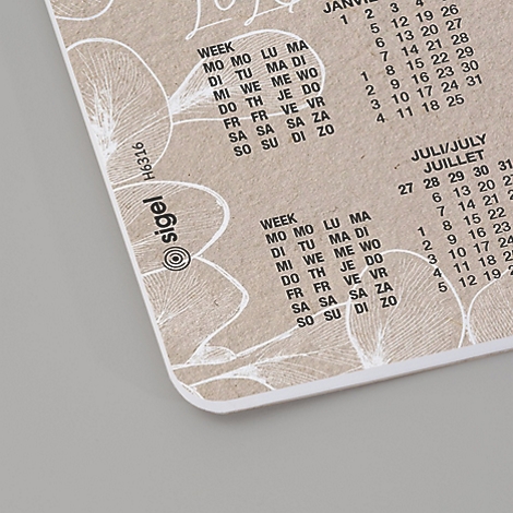 Close-up van een beige kalender met bloempatronen die de maanden januari en juli weergeven met weekdagen en datums.