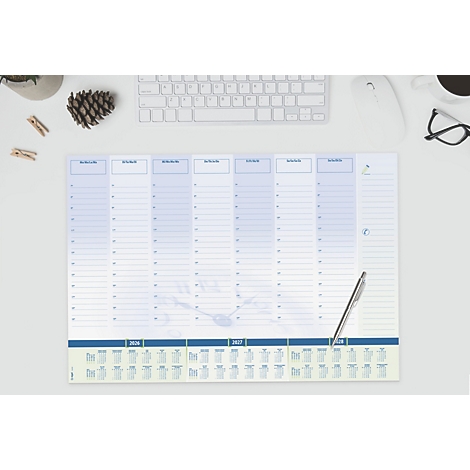 Lichtblauwe wekelijkse bureaubladkalender, pen, toetsenbord, bril, dennenappel en decoratie.