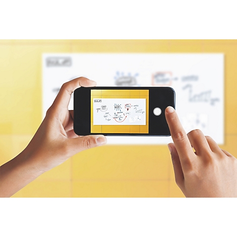 Une personne photographie une présentation avec un smartphone. Doigts touchant le téléphone. Fond jaune.