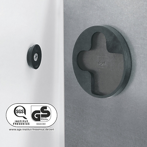 Gros plan : Couvercle en plastique noir avec renfoncement en forme de croix et un couvercle rond sur une surface blanche.