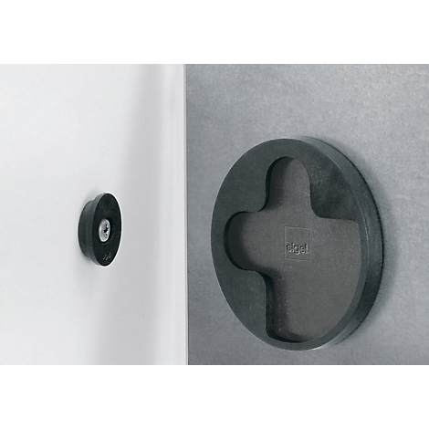 Deux pièces en plastique noir. L'une est ronde et fixée à un mur blanc. L'autre est ronde avec une découpe en forme de quatre feuilles et fixée à un mur gris.