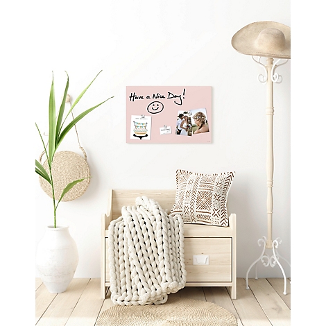 Mur avec un tableau d'affichage et des éléments décoratifs. Sur le tableau d'affichage : 'Have a Nice Day !' avec smiley et photos. Devant, un banc avec un coussin et une couverture.