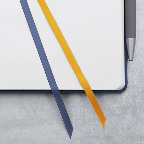 Notizbuch mit blauem und gelbem Lesezeichen und einem Stift.