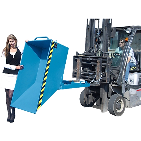 A woman stands next to a blue tipping skip held by a forklift. There is a yellow and black stripe on the skip.