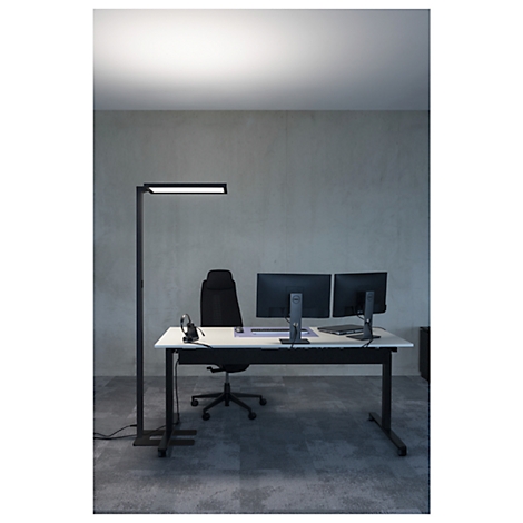 Bureau met twee monitoren, bureaustoel, vloerlamp met LED-licht.