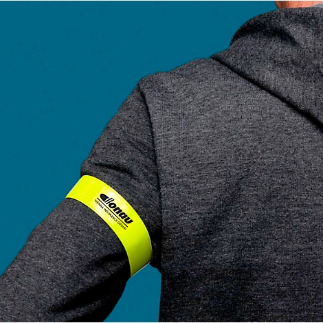 Person trägt einen grauen Hoodie. Am Arm ist eine gelbe Armbinde mit dem Logo "allonau" zu sehen.