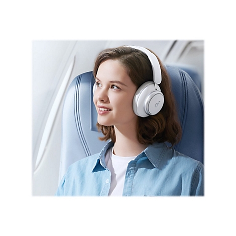 Junge Frau im Flugzeug mit weiÃŸen KopfhÃ¶rern, lÃ¤chelnd.