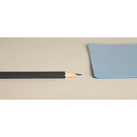 Un crayon avec une mine pointue est posé à côté d'un papier bleu clair sur un fond beige.