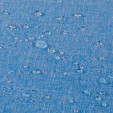 Gros plan sur un tissu bleu avec des gouttelettes d'eau qui s'accumulent dessus.