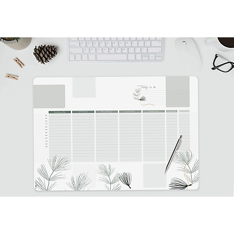 Tapis de bureau avec un planificateur hebdomadaire et des éléments floraux. Stylo, clavier et autres accessoires sont sur la table.