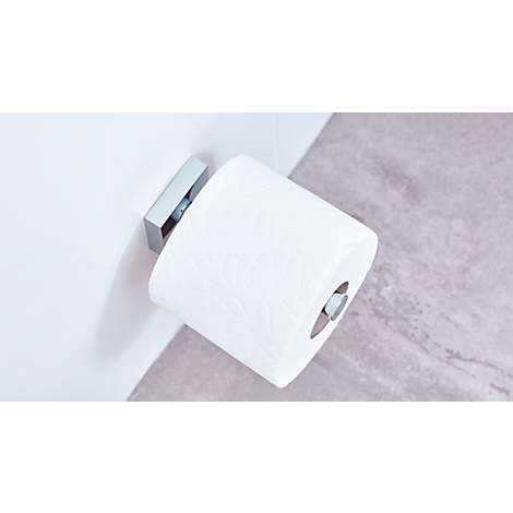 White toilet paper hanging on a silver holder on the wall. A marbled surface can be seen in the background.