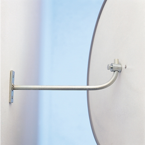 Een metalen arm aan de muur bevestigd, houdt een ronde witte plaat vast.