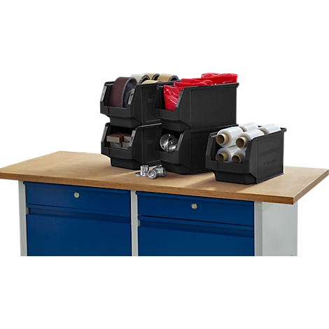 Bac de rangement noir avec des outils sur un établi. Armoires bleues en dessous.