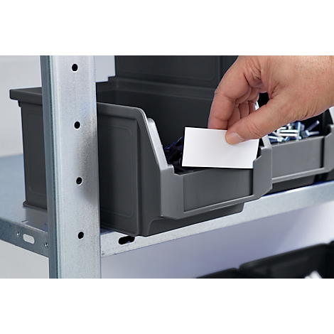 Hand greift in Schublade. Graue Schubladen auf Metallregal. Eine weiße Karte wird platziert.