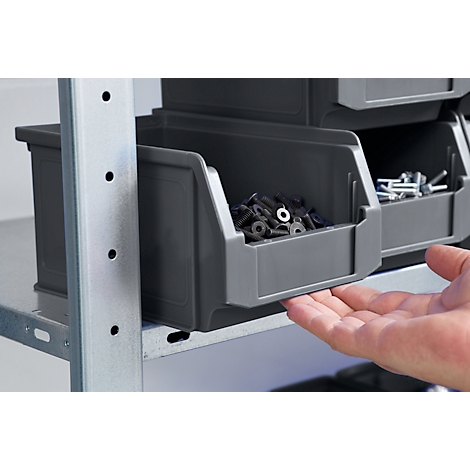 Graue Schubladen, gefüllt mit Schrauben, auf einem metallenen Regal, eine Hand öffnet die Schublade.