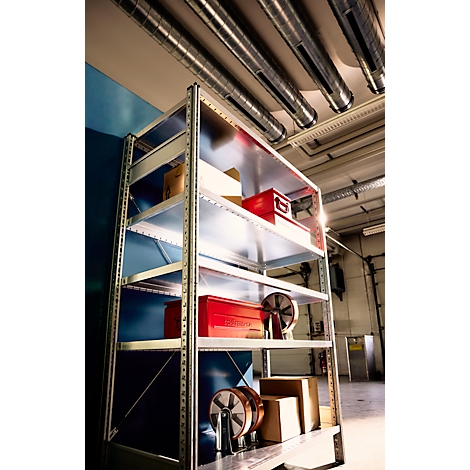 Metallregal mit roten Werkzeugboxen und Rollen in einem Lagerraum mit Rohren an der Decke.