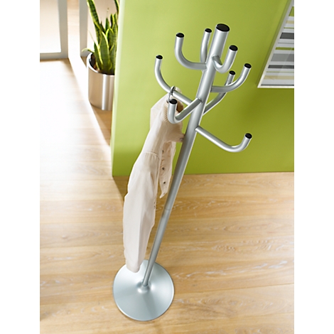 Moderne zilverkleurige staande kapstok met jas in een hal met een limoengroene muur.