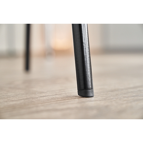 Close-up of a black chair leg standing on a wooden floor. The focus is on the bottom of the leg.