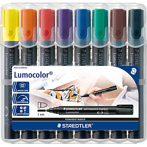 Set of colorful felt-tip pens in a transparent plastic package. A black pen is next to it. Prints: "Lumocolor", "STAEDTLER".
