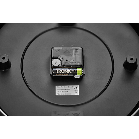 Back of a clock: black plastic, clockwork with battery, manufacturer's label.