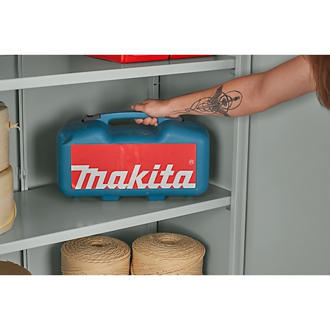 Een hand houdt een blauwe Makita gereedschapskist in een grijze kast. Daaronder liggen klosjes garen.