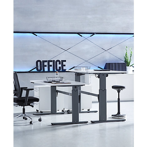 Twee in hoogte verstelbare bureaus in een modern kantoor voor een muur met het woord Office.