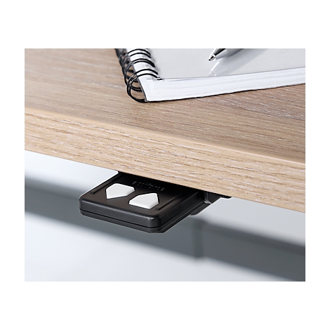 Wood-grained desk. Underneath a black control with white arrow keys.