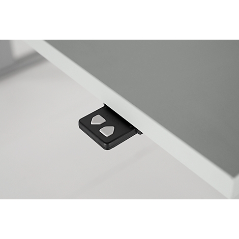 Close-up of a table top and a black control unit with silver arrow keys.