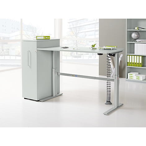 Light gray height-adjustable desk with integrated cabinet against a bright background.