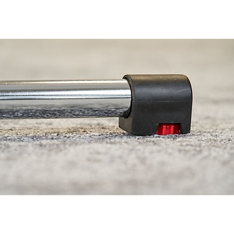 Detail shot of the end of a metallic tube ending in a black plastic part with a red button.