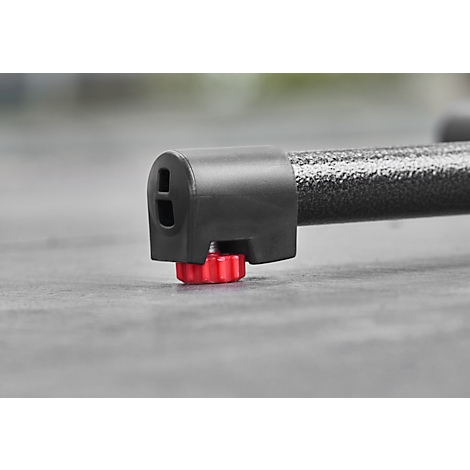 Close-up of black plastic foot with red, ribbed adjusting wheel.