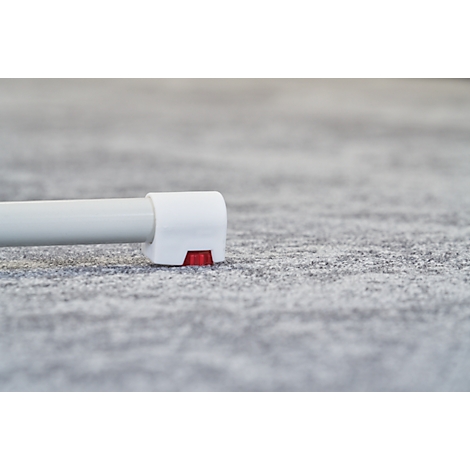 Close-up of a white product detail with a red element on a gray, textured background.