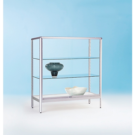 Ein modernes Glasregal mit drei transparenten Regalböden, darauf eine schwarze Vase und eine weiße Schale.