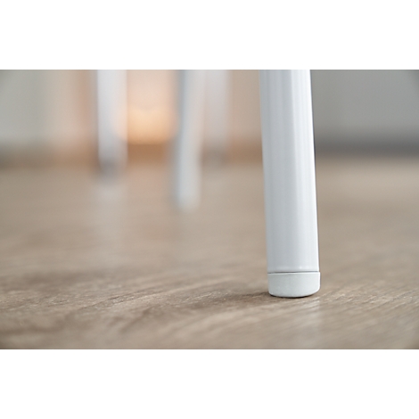 Close-up van een witte stoelpoten op een lichte houten vloer. De poten is cilindrisch met een licht afgeronde voet.