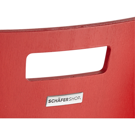 Close-up van een rode stoel. Een rechthoekige handgreepuitsparing met afgeronde hoeken en een "SCHÄFERSHOP"-bord.